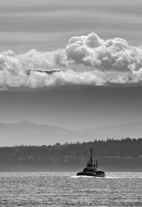 Photo of tugboat on puget sound with clouds in the background