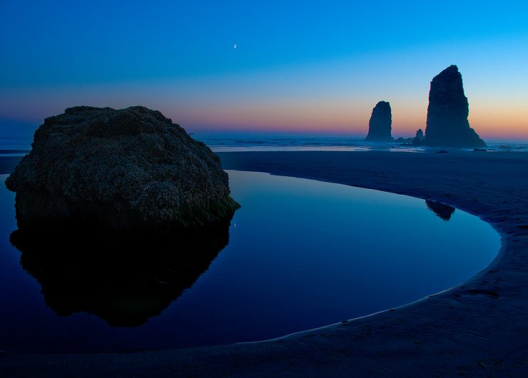 Photo of sea stacks and sunset reflected in tide pool at Canon Beach.