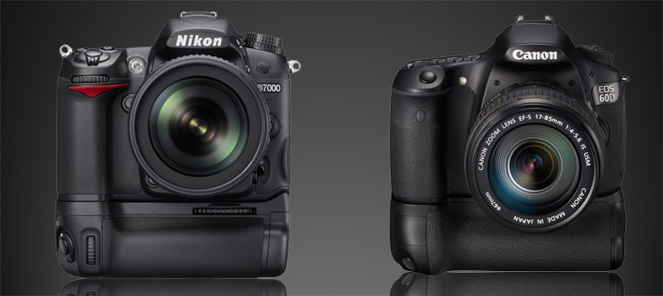 A Nikon D7000 and a Canon 60D, each with battery grip