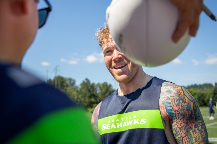 Cassius Marsh signs items for fans at training camp.
