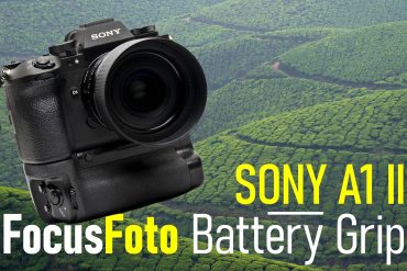 camera with battery grip in front of tea fields and hills